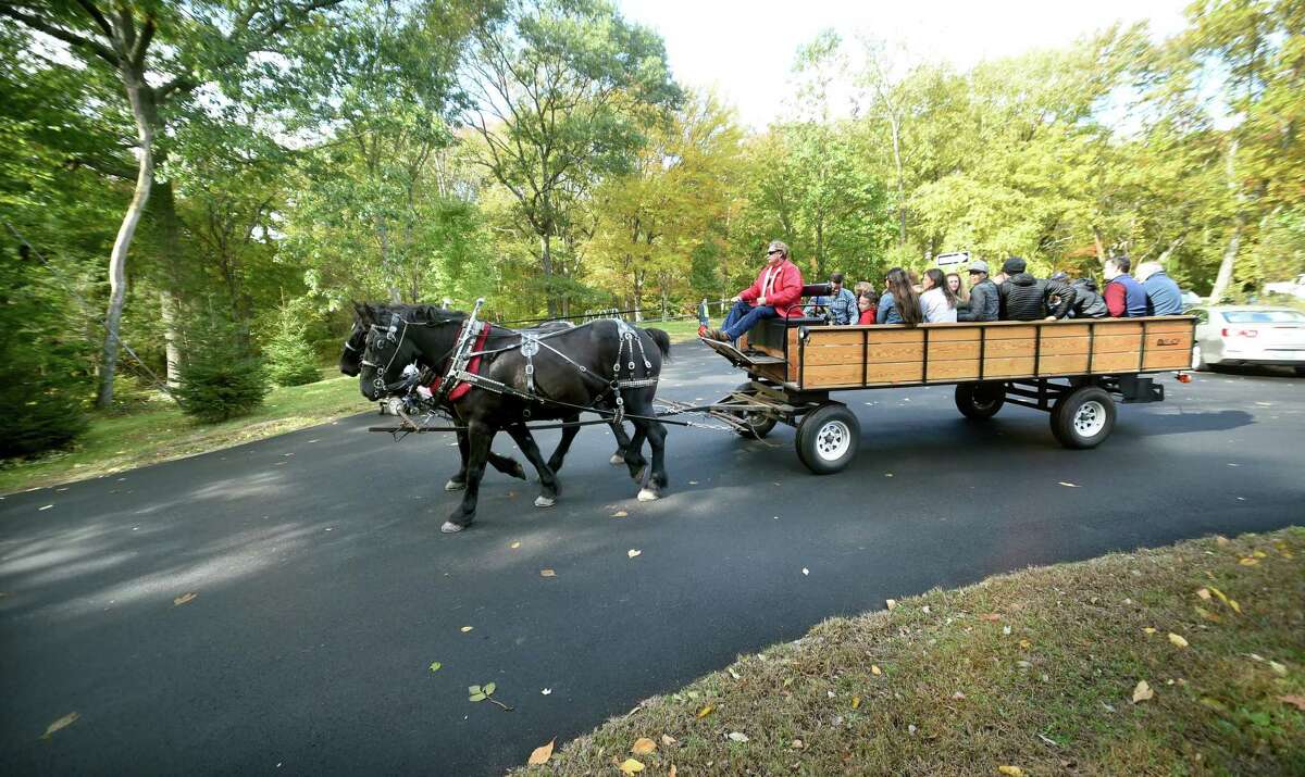 Children and their parents begin a horse drawn wagon ride during the Autumn Festival at the Ansonia Nature Center on October 20, 2018.