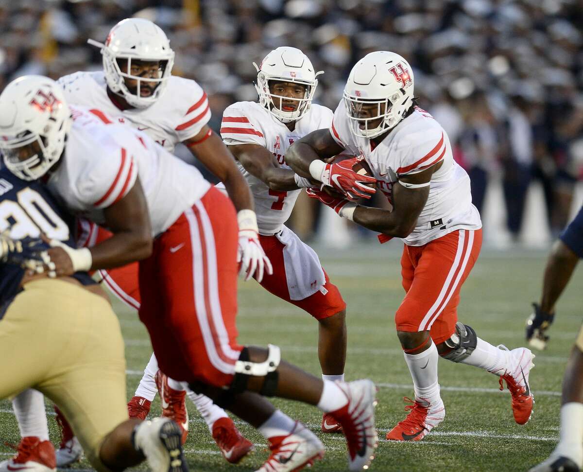 Houston quarterback D'Eriq King (4) hands off to running back Terence Williams, right, in the fourth quarter against Navy at Navy-Marine Corps Memorial Stadium in Annapolis, Md. The visiting Cougars won, 49-36. (Paul W. Gillespie/Capital Gazette/Baltimore Sun/TNS)