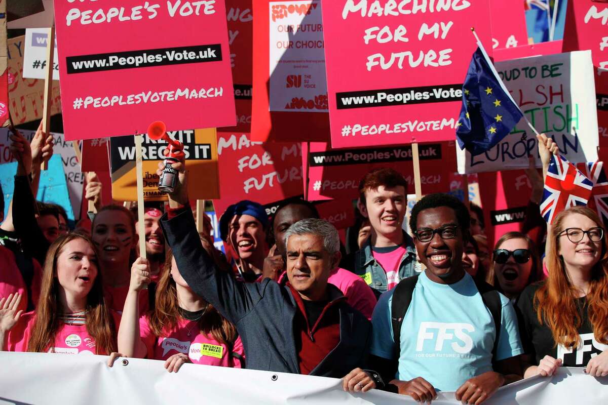 Mayor of London Sadiq Khan, front centre, holds a klaxon horn, as he joins protesters in the People's Vote March for the Future, in London, Saturday Oct. 20, 2018. Some thousands of protesters are marching through central London, Saturday, to demand a new referendum on Britain?’s Brexit departure from the European Union. (Yui Mok/PA via AP)