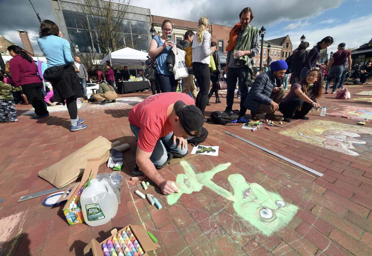 Vincent Shamansky of Hamden draws a witch during the New Haven Chalk Art Festival on the Broadway Island in New Haven on October 20, 2018.
