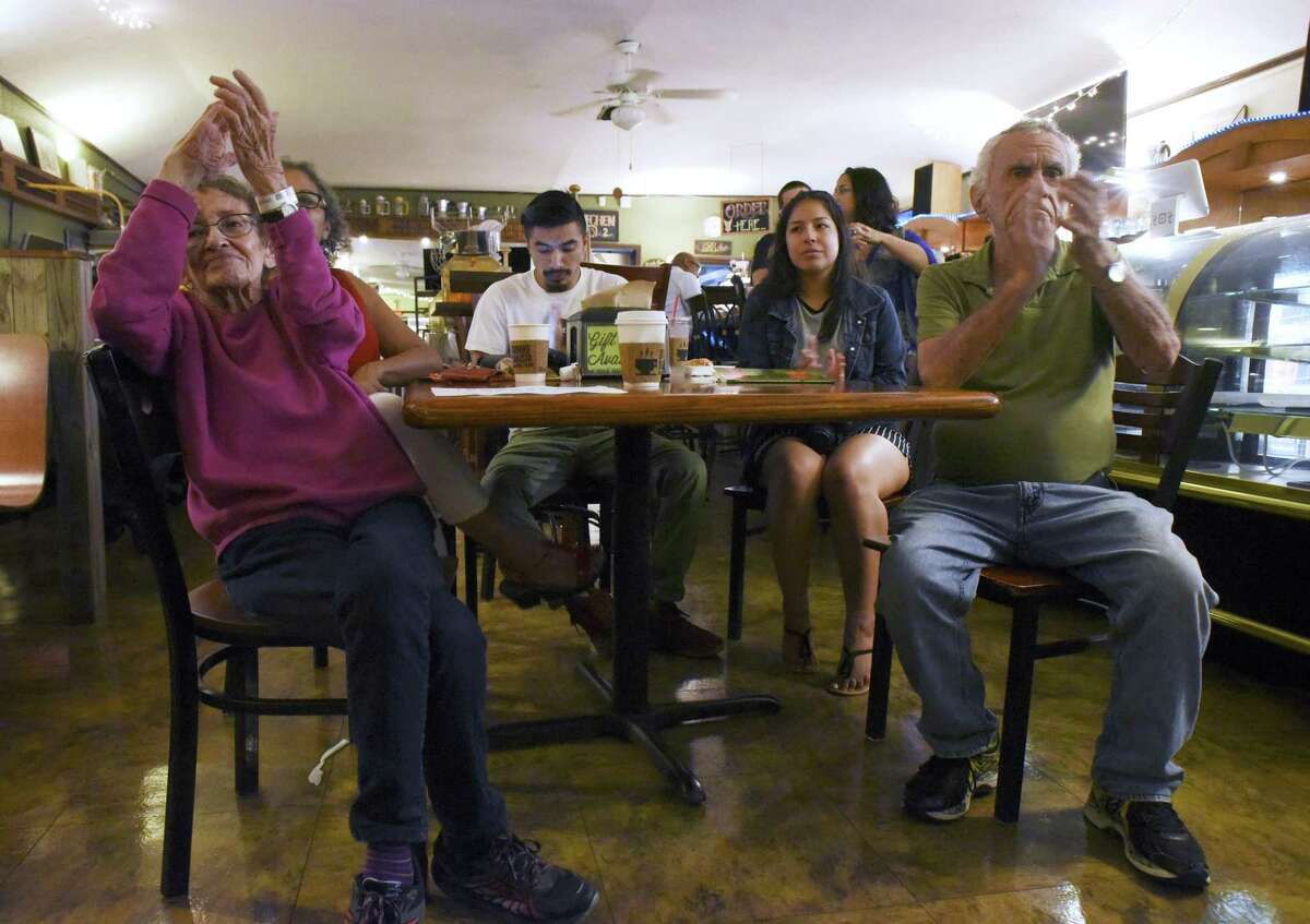 Marilyn Keene, left, her husband, Tom, right, and others applaud during open mic night at Barrio Barista, where poets from all walks of life connect with the audience