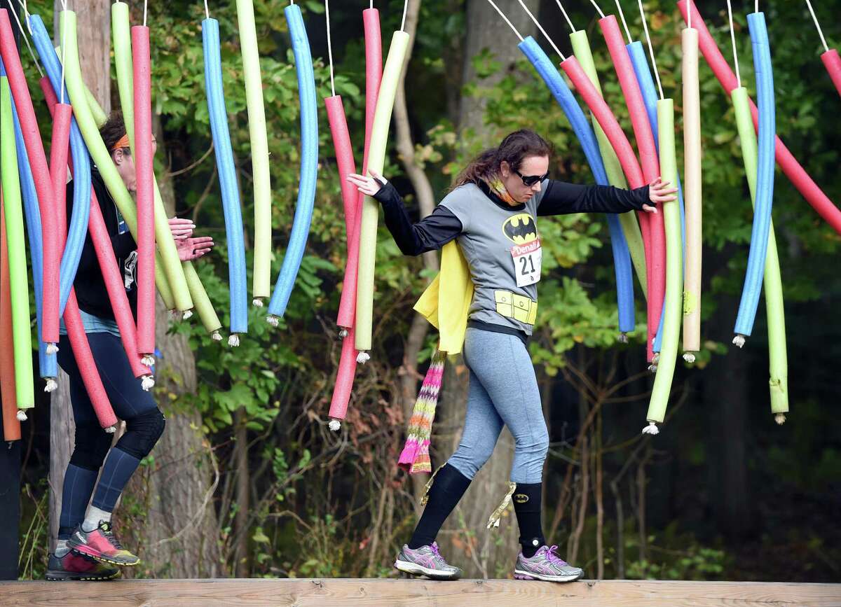 Runners navigate through one of 15 man-made and natural obstacles during the first heat of Denali's 7th Annual Fall Run the Gauntlet Race at Lighthouse Point Park in New Haven on October 21, 2018.