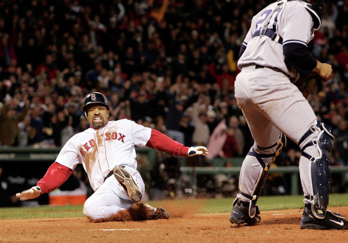 FILE - In this Oct. 17, 2004, file photo, Boston Red Sox's Dave Roberts, left, slides home to score the tying run past New York Yankees' Mariano Rivera in the ninth inning of Game 4 of the American League Championship Series in Boston. Roberts entered the game as a pinch-runner and came around to score as the Red Sox rallied to defeat the Yankees, come back from a 3-0 deficit in the series and go on to win their first World Series in 86 years. Roberts returns to Fenway Park on Tuesday, Oct. 23, 2018, as the Dodgers manager as Los Angeles faces Boston in the World Series. (AP Photo/Elise Amendola, File)