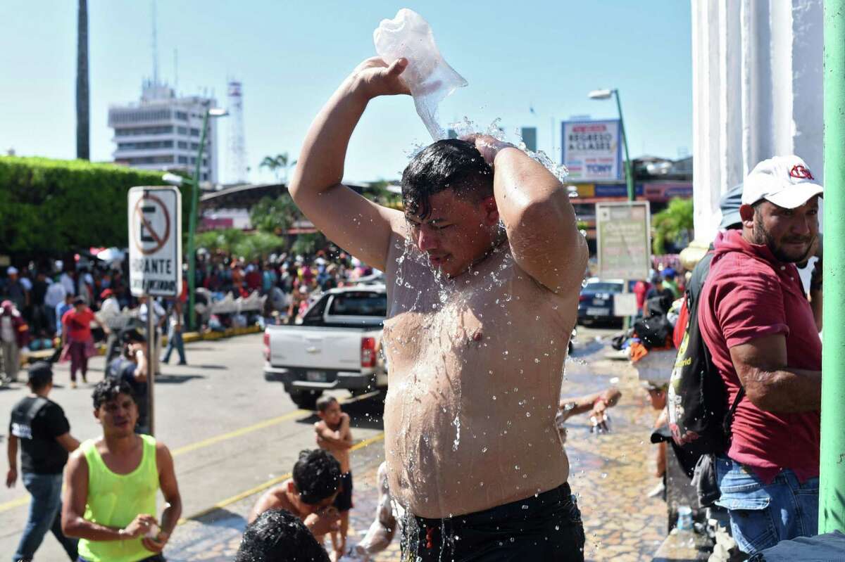 A Honduran migrant heading in a caravan to the US, takes an improvised shower in Tapachula, Chiapas state, Mexico, on October 22, 2018. - President Donald Trump on Monday called the migrant caravan heading toward the US-Mexico border a national emergency, saying he has alerted the US border patrol and military. (Photo by Johan ORDONEZ / AFP)JOHAN ORDONEZ/AFP/Getty Images