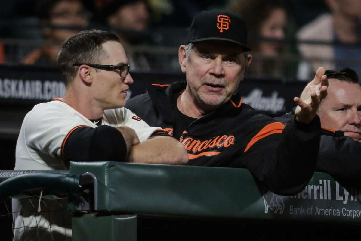 Giants' manager Bruch Bochy (15) (center) chats with player Kelby Tomlinson (37) (left) during a game between the San Francisco Giants and the Milwaukee Brewers at AT&T Park in San Francisco, Calif., on Tuesday, Aug. 22, 2017.