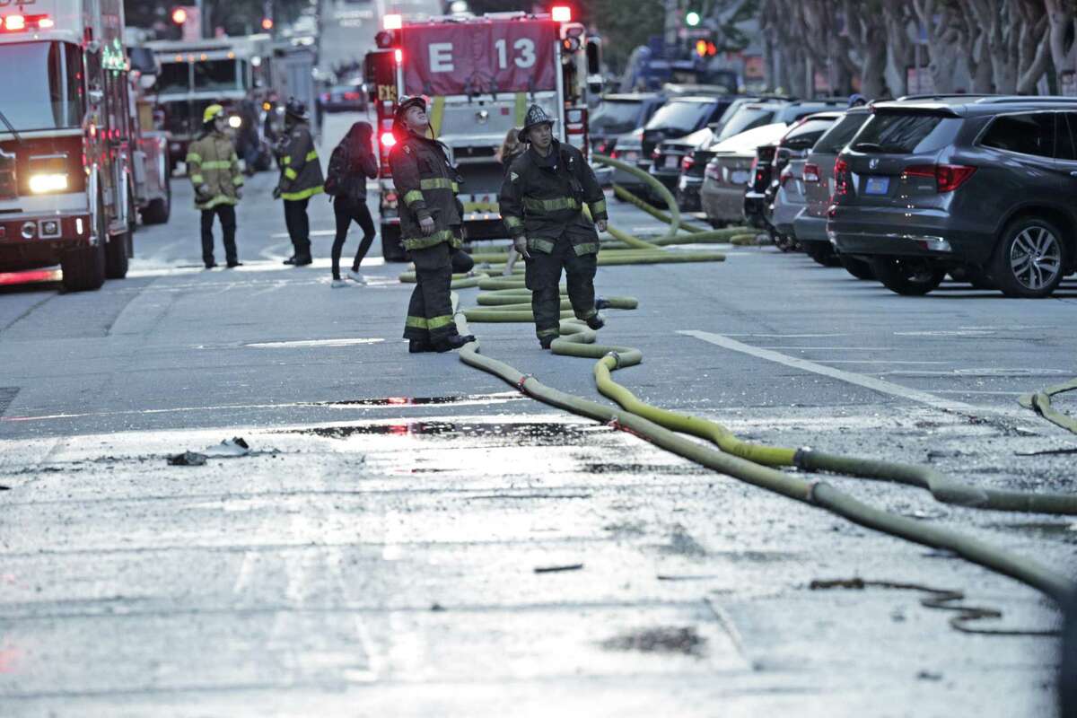 Fire hoses laying in the street as firefighters finish working a fire in a high-rise apartment building on Davis Court in San Francisco on Monday Oct. 22, 2018.