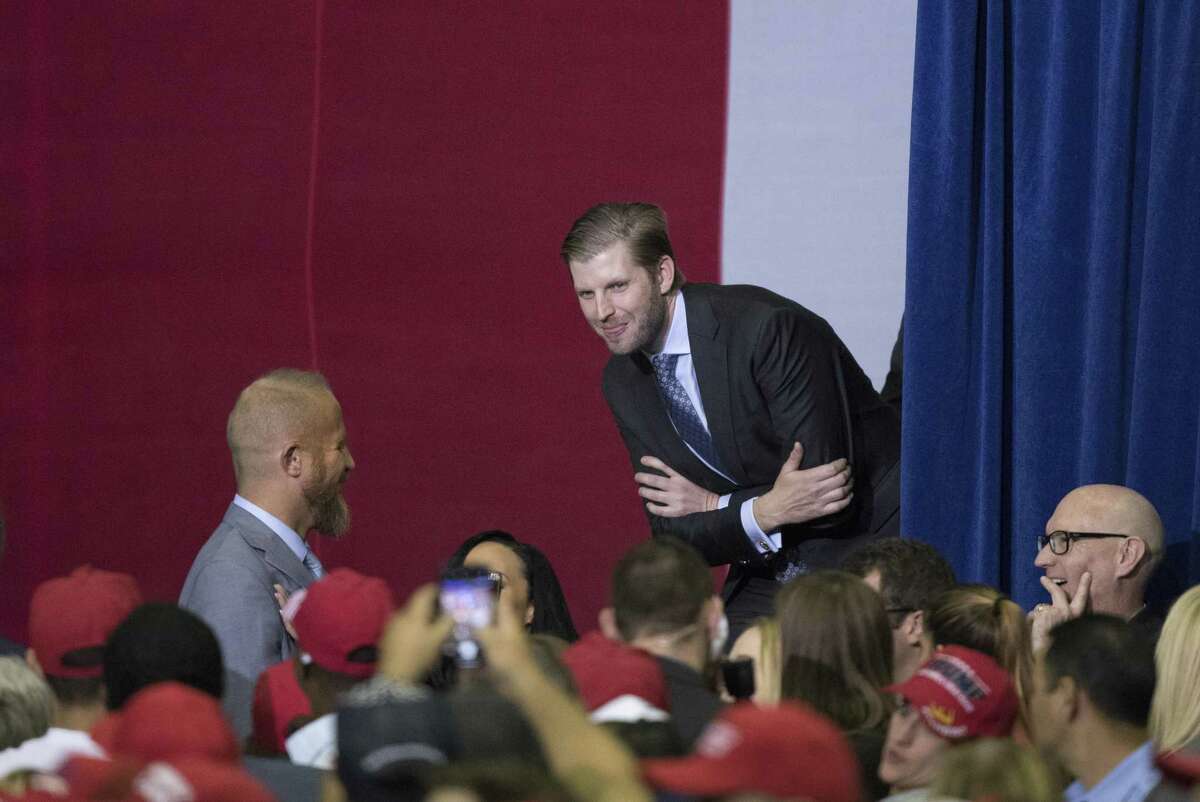 Eric Trump peeks out smiling at the audience as his wife Lara Trump gives a speech during a rally on Monday, October 22, 2018 at the Toyota Center in Houston, Texas.