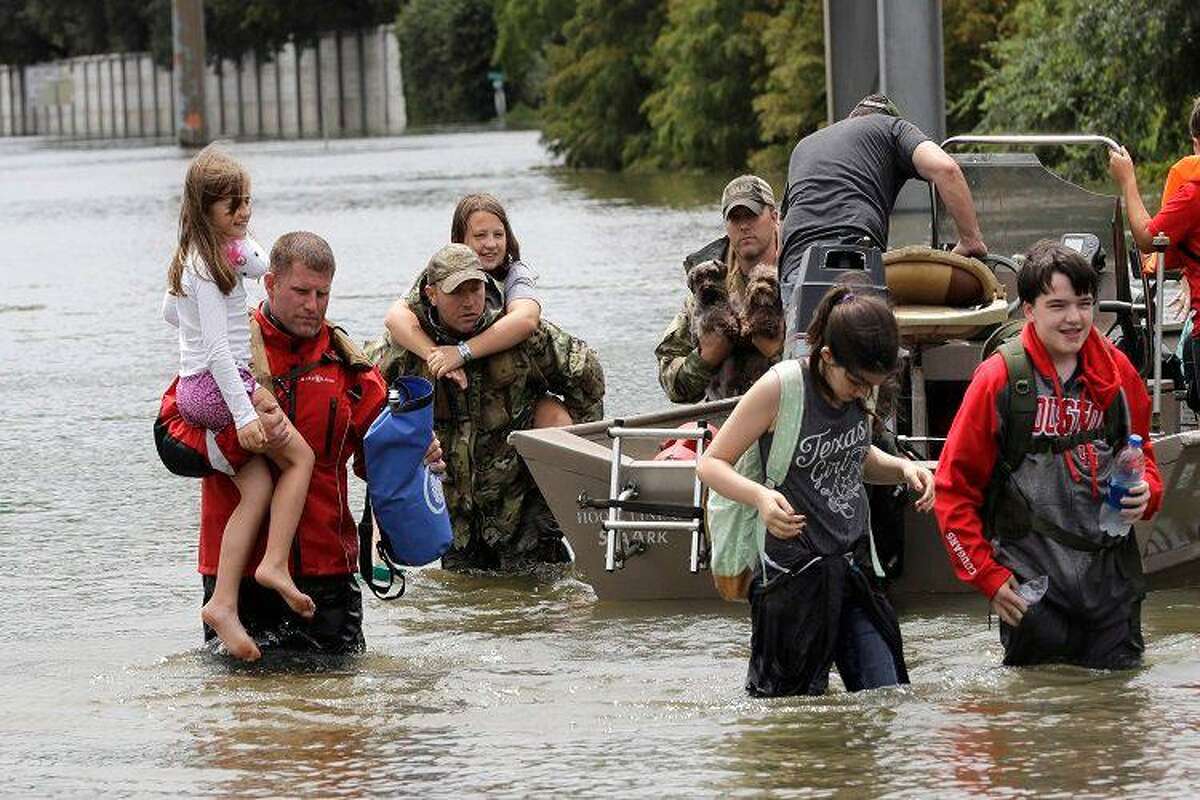 Residents are rescued from their homes surrounded by floodwaters from Tropical Storm Harvey on Sunday, Aug. 27, 2017, in Houston, Texas.