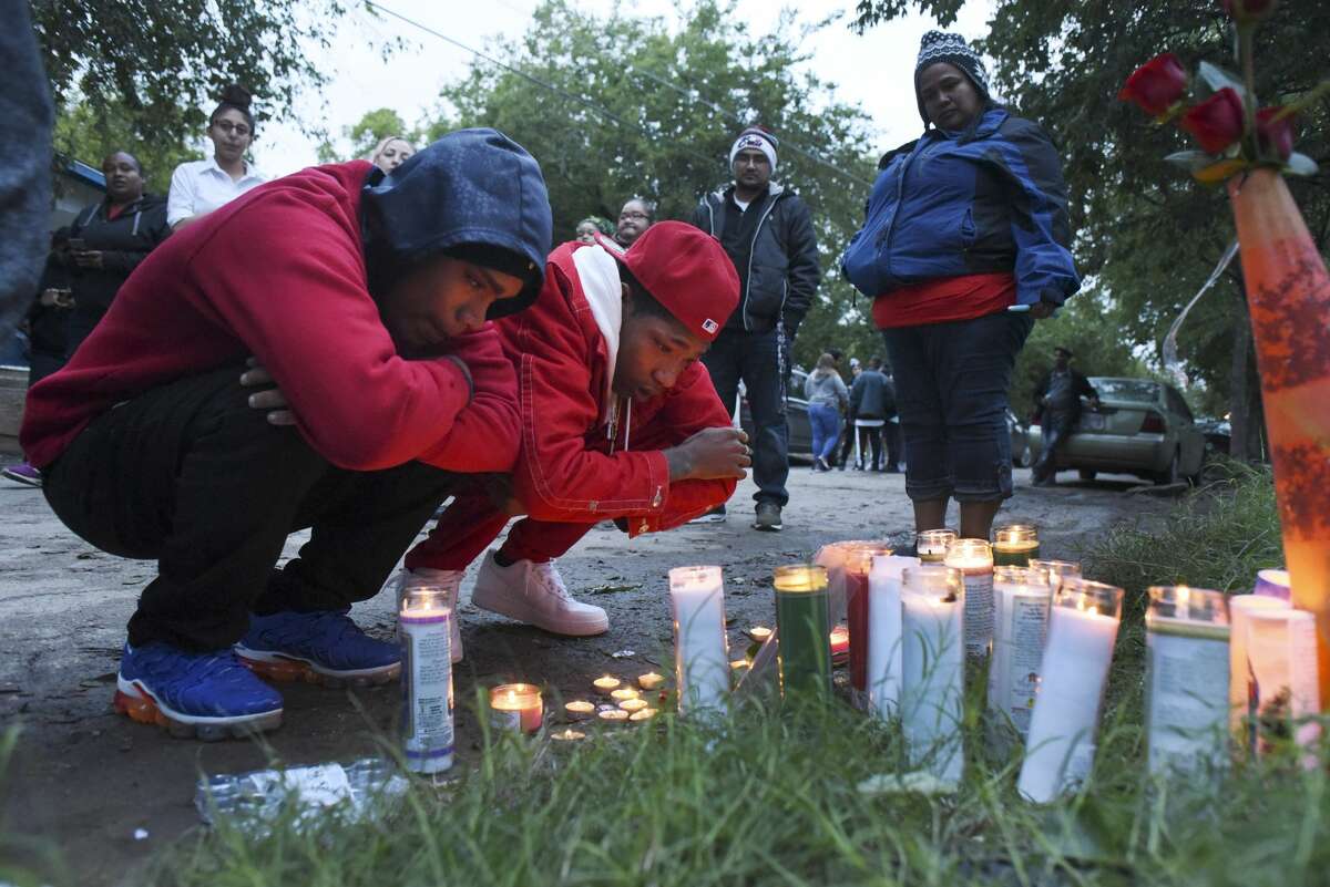 Jordan Medina, left, and Jason Caldwell pay their respects at a makeshift memorial put up by friends and family of Charles Roundtree, an 18-year-old who was shot and killed by San Antonio police early Wednesday in the 200 block of Roberts Street, on Wednesday night, Oct. 17, 2018. Caldwell is Roundtree's brother. Roundtree was unarmed and was struck by a bullet fired at another person.