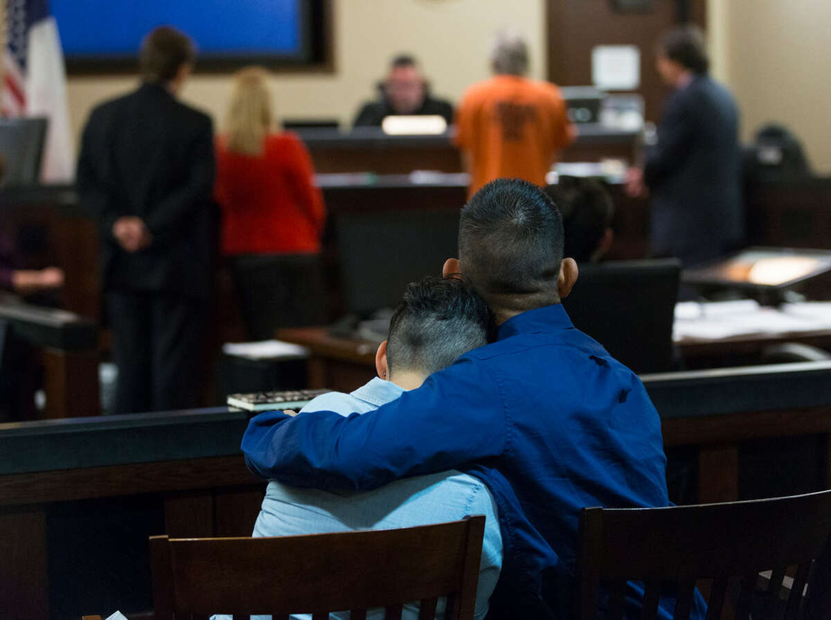 Abigail Alvarado, in foreground at left, is hugged by her husband, Rudy, Tuesday, Oct. 23, 2018 in the 187th state District Court in the Cadena-Reeves Criminal Justice Center as Judge Joey Contreras, center, sentences Eusebio Castillo, second from right, to multiple life sentences in prison. Castillo, Abigail Alvarado's uncle and adoptive father, was convicted on multiple counts spanning many years of sexual abuse and rape of Alvarado starting as early as when she was 9 years old and fathering three children with her as a result of the rapes.