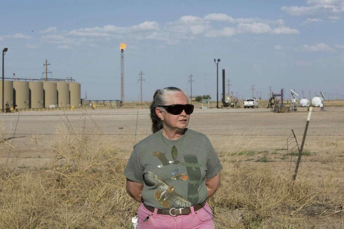 Suzanne Franklin stands near her home in Reeves County, West Texas, on April 11, 2018. Some mornings Franklin wakes with a nose full of dried blood, her voice filled with gravel. Her husband Jim suffers from respiratory problems, too. Complaints like hers are common among people who live near gas sites, academic research has found. Flares burning off gas spew pollutants that assault the respiratory system. (Marjorie Kamys Cotera/The Texas Tribune via AP)