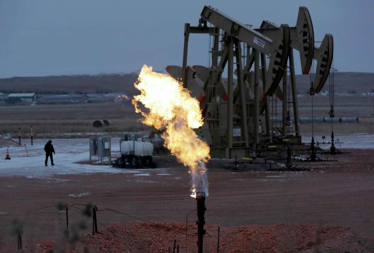 Workers tend to oil pump jacks behind a natural gas flare near Watford City, N.D in this 2015 photo. The Republican-controlled Congress is moving to overturn an Obama administration rule intended to clamp down on oil companies that burn off natural gas during drilling operations on public lands.