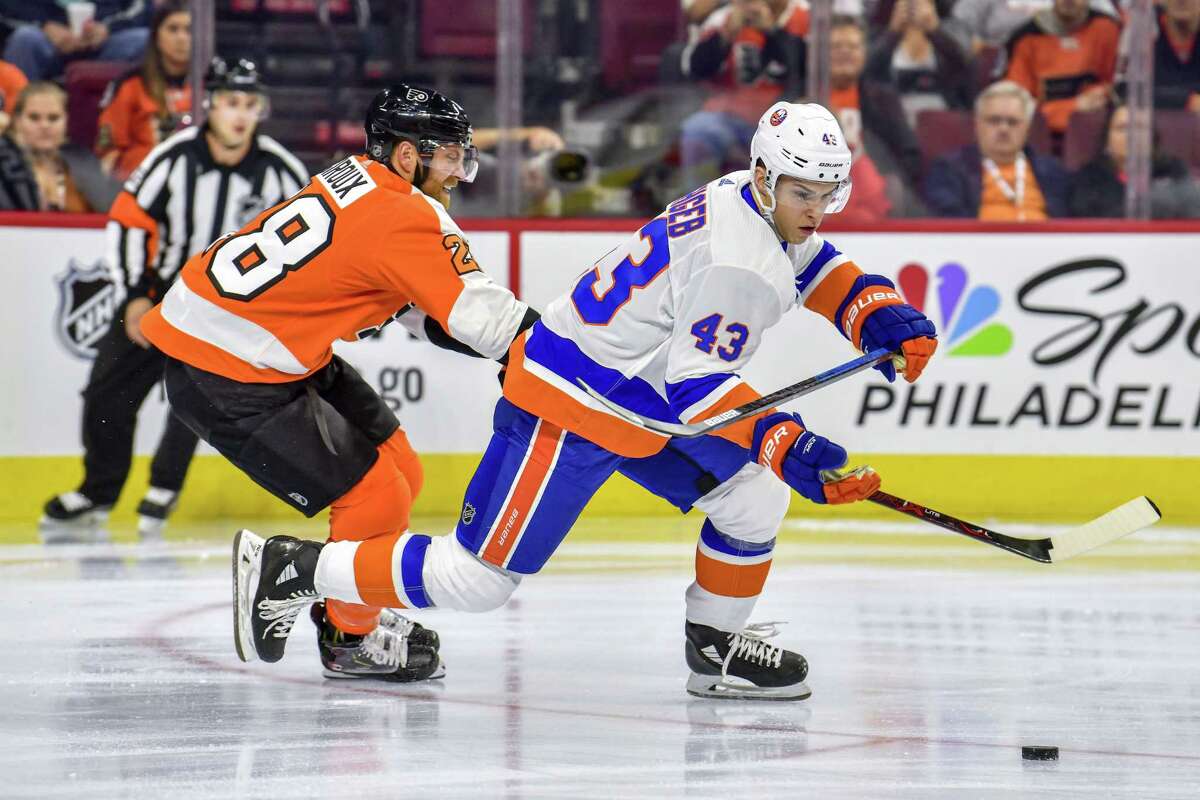 Philadelphia Flyers center Claude Giroux (28) tries to steal the puck from New York Islanders defenseman Yannick Rathgeb (43) during a preseason game on Sept. 17 at the Wells Fargo Center in Philadelphia, Pa.