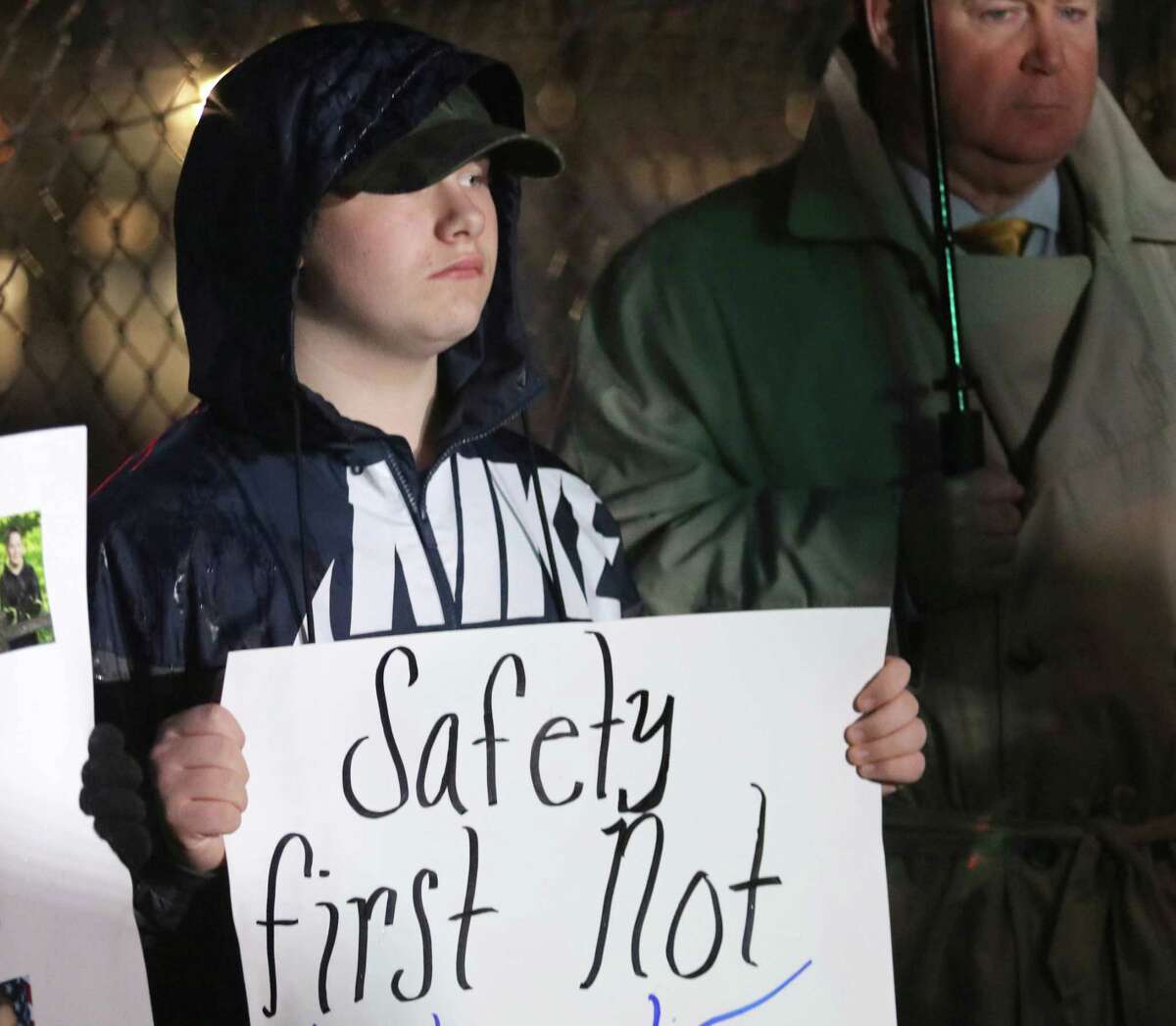 Saratoga Springs High School tenth grader Hunter Coons holds a sign supporting re-arming school monitors outside Saratoga Springs High School before attending the Saratoga Springs School District's Board of Education meeting Tuesday, October 23, 2018. Retired NYS trooper John Neeley stands at right. (Ed Burke photo-Special to The Times Union)