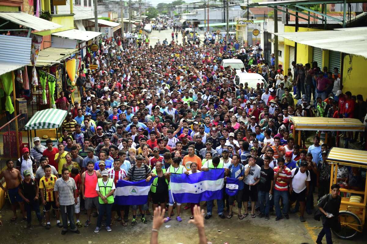 Honduran migrants heading in a caravan to the United States, hold a demonstration demanding authorities to allow the rest of the group to cross, in Ciudad Hidalgo, Chiapas state, Mexico after crossing from Guatemala, on October 20, 2018. Thousands of migrants who forced their way through Guatemala's northwestern border and flooded onto a bridge leading to Mexico, where riot police battled them back, on Saturday waited at the border in the hope of continuing their journey to the United States.