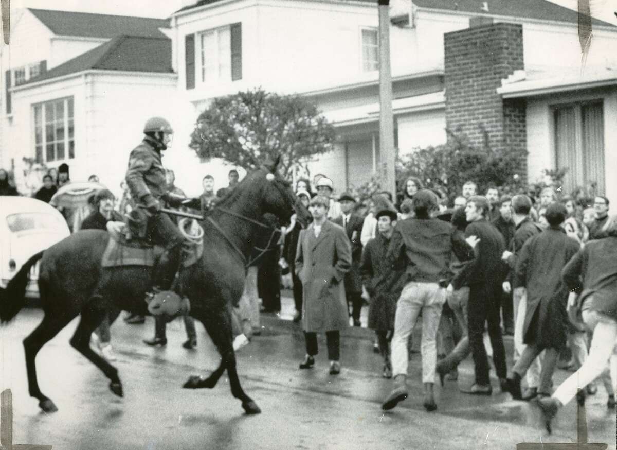在19街和Holloway st街，骑着马的警察穿过一群持不同政见的学生。1968年12月9日，合众国际社照片，在旧金山州立大学学生示威期间，示威者投掷石块，引发骑警的行动