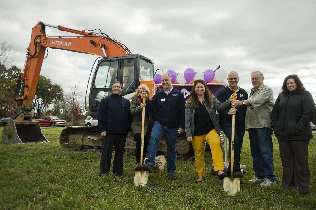 Midland's Open Door Executive Director Renee Pettinger, fourth from right, Greystone Homes owner Kelly Wall, third from left, and others pose for a photo during a groundbreaking for a home being built by Greystone Homes, the proceeds of which will be donated to Midland's Open Door once the home is sold, on Wednesday, Oct. 24, 2018 in Midland. (Katy Kildee/kkildee@mdn.net)