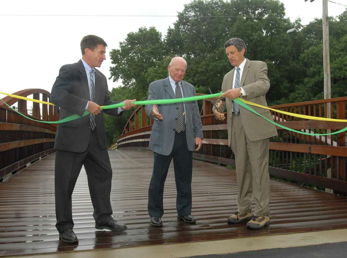 Brad Horrigan | New Haven Register. BH0367. Hamden, Connecticut - 06.18.09: Hamden Mayor Craig Henrici and Connecticut State Sen. Joseph J. Crisco hold the ribbon as David Schaefer, chairman of the Farmington Canal Greenway Commission in Hamden, cuts it. The Hamden portion of the Farmington Canal Greenway is now complete.