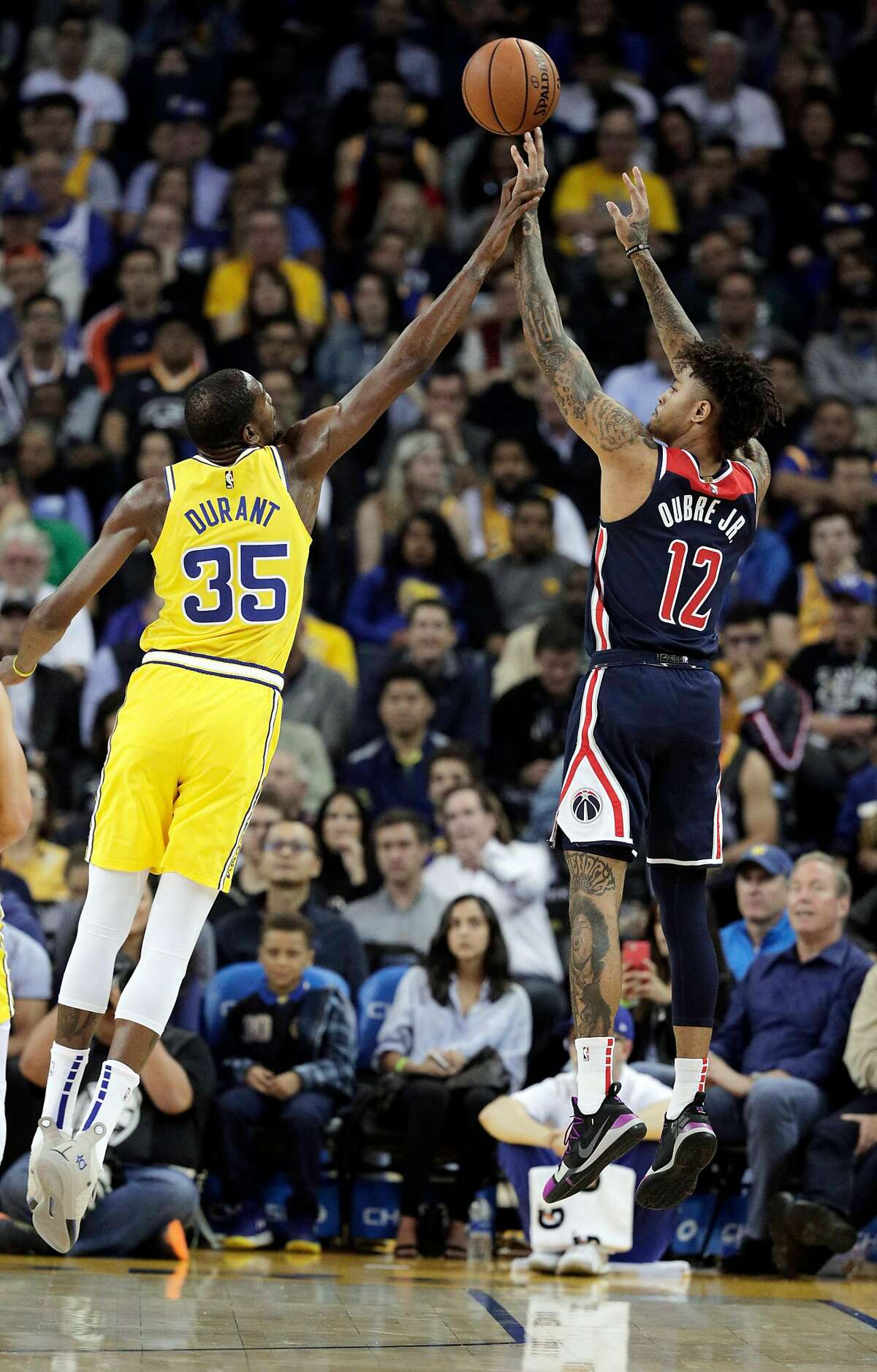 Kevin Durant (35) tries to block a shot by Kelly Oubre Jr., (12) in the first half as the Golden State Warriors played the Washington Wizards at Oracle Arena in Oakland on Wednesday, Oct. 24, 2018. 
