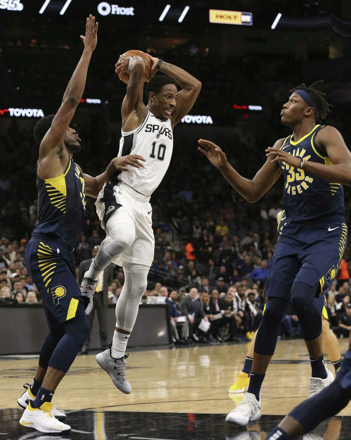 San Antonio Spurs?’ DeMar DeRozan passes the ball as Indiana Pacers?’ Thaddeus Young, left, and Myles Turner defend during the first half at the AT&T Center, Wednesday, Oct. 24, 2018.