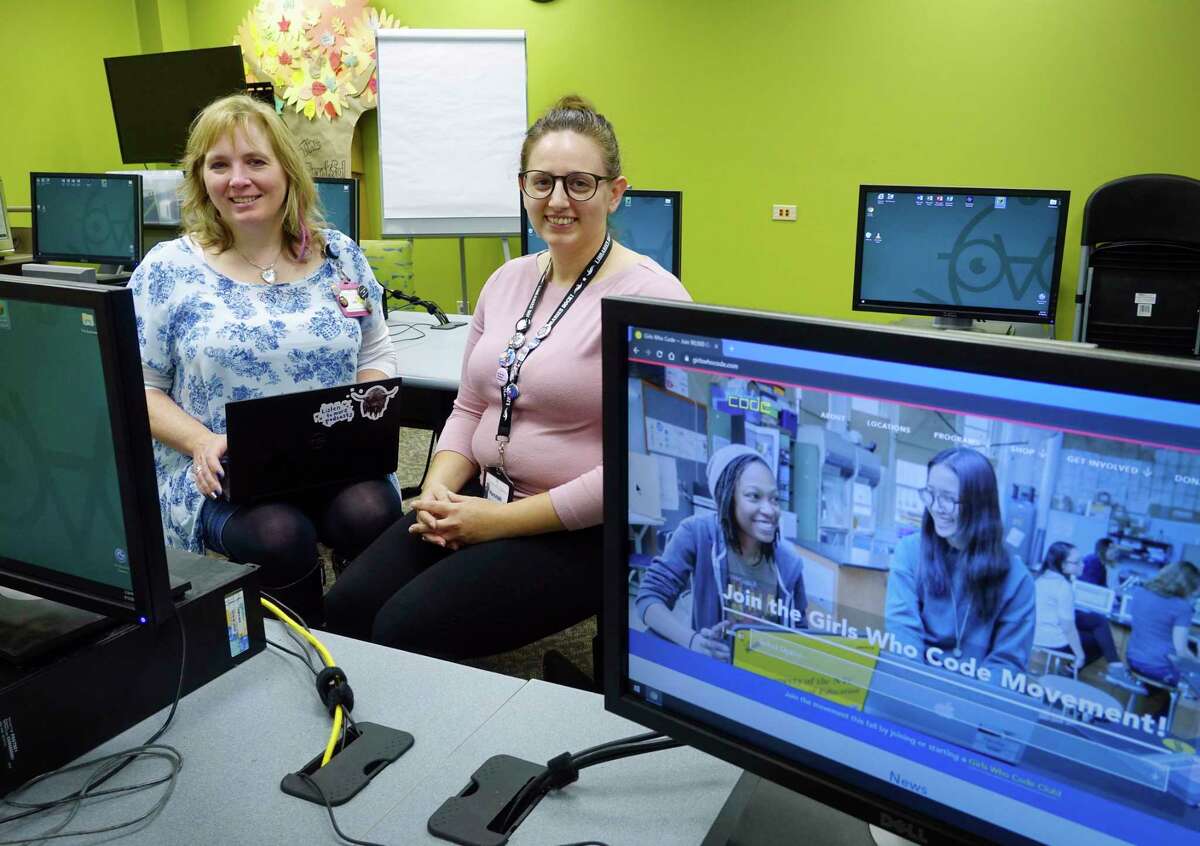 Lisa Newman, left, head of Youth Services for the Albany Public Library, and Hannah Ricottilli, a librarian assistant, pose for a photo in the computer lab at the main branch on Wednesday, Sept. 12, 2018, in Albany, N.Y. The two women are running the Girls Who Code program. The eight-week sessions in the fall and the spring teach coding to girls ages 11 to 17. (Paul Buckowski/Times Union)
