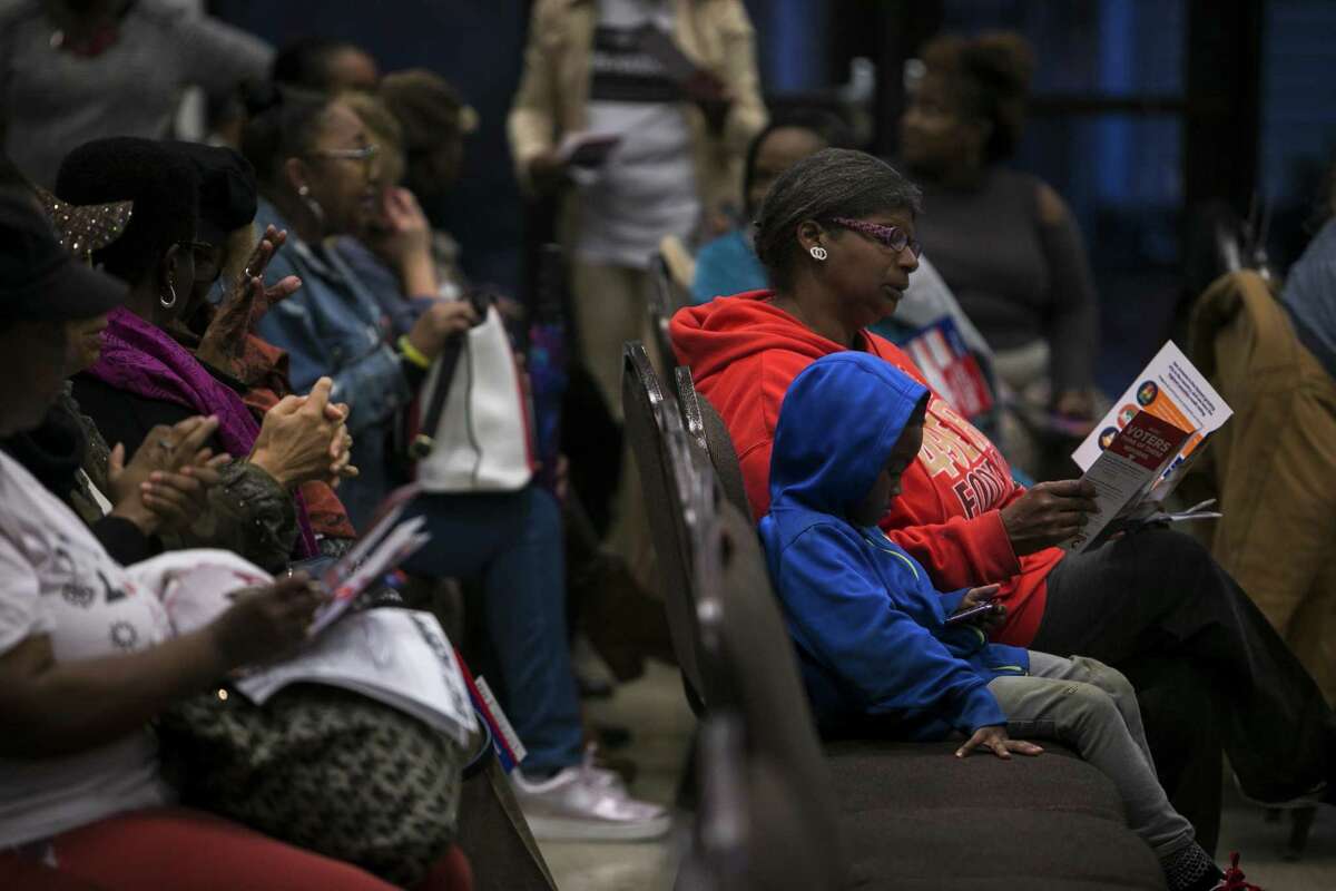 Attendees look over literature distributed at an Oct. 18 town hall meeting held at the Beasley Brown Community Center. The meeting provided a chance for the where the Go Vote No and San Antonio First campaigns to share their stances and answer questions about the propositions.