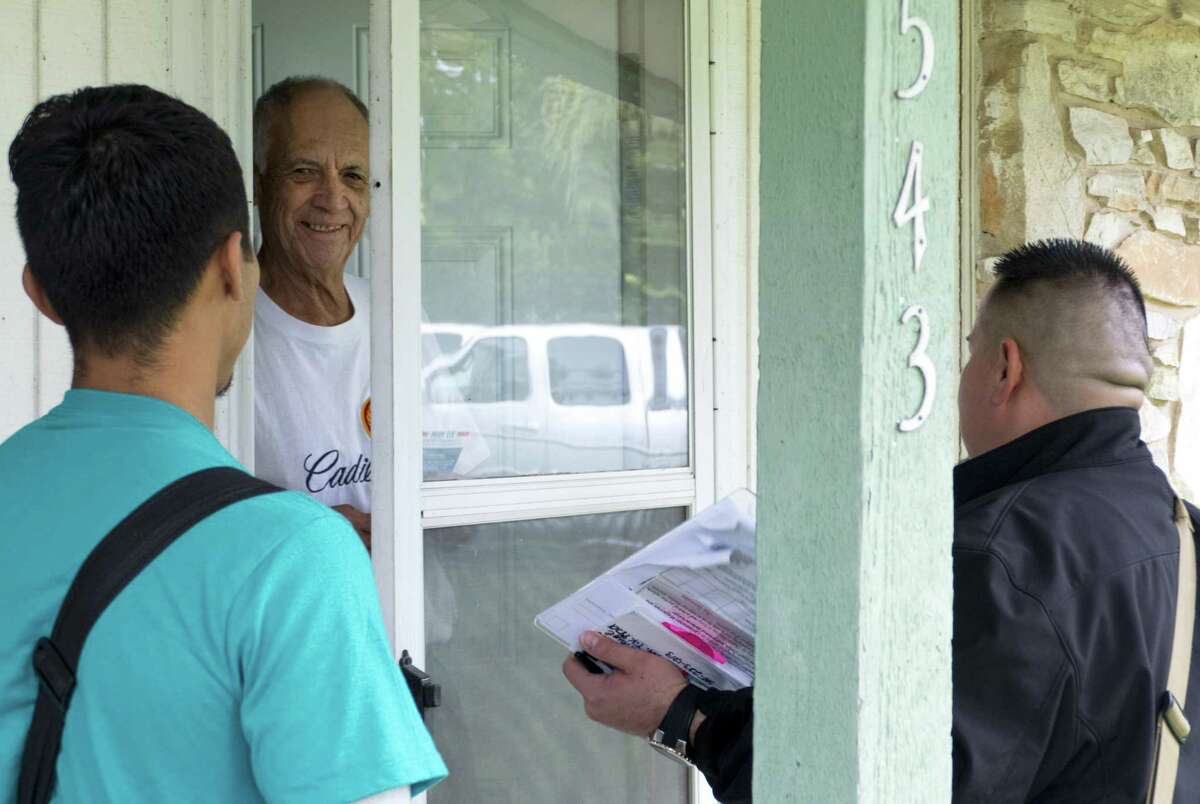 Alan Rivas, right, and Jeremiah Lopez, left, of the Texas Organizing Project, speak with Jacinto Hernandez during a block walk to inform voters about city charter amendments in October 2018. The organization is well known for its ability to get out the vote and Mayor Ron Nirenberg is seeking TOP’s endorsement in the June 8 runoff, where he’s facing challenger Councilman Greg Brockhouse. Brockhouse also is seeking the group’s endorsement.