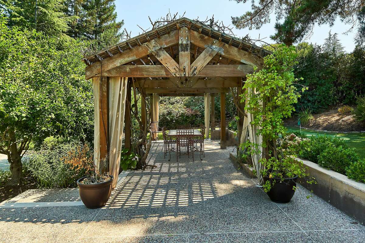 The secluded estate enjoys a wealth of outdoor spaces, like this sheltered patio and putting green.