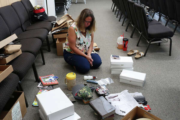 Sherri sorts through boxes of unclaimed belongings  The boxes were returned to her from the District Attorney's Office, which was involved in the shooting investigation.