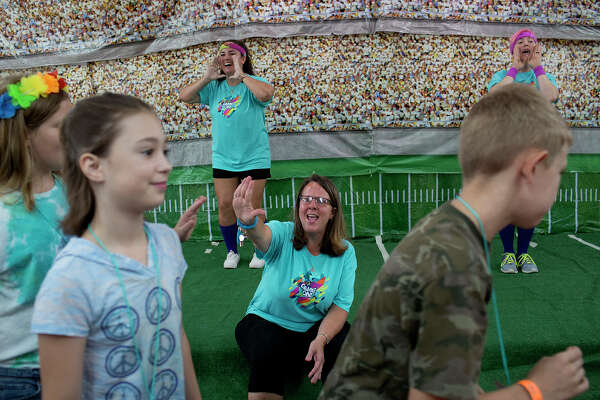 Sherri Pomeroy, center, with Britteny Martinez, left, and Colbey Workman, get Vacation Bible School students singing and dancing in an event at the church.