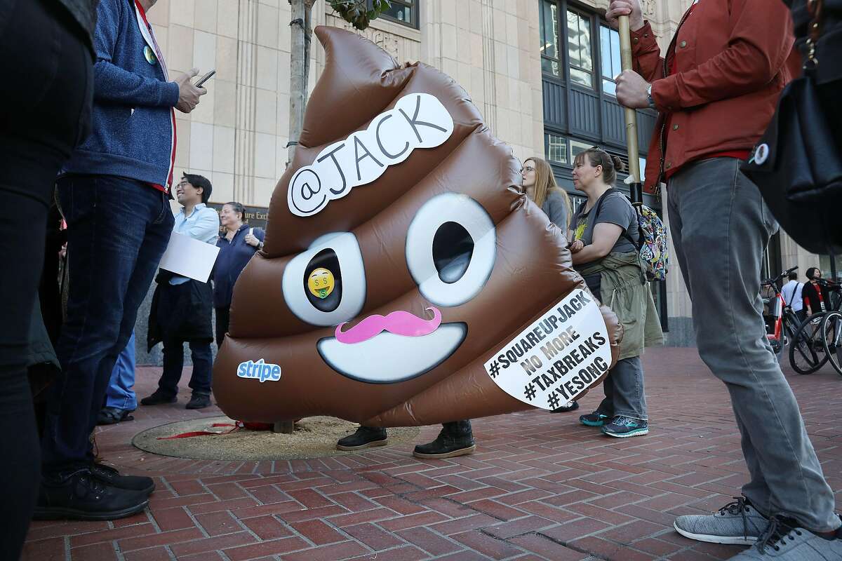 Housing activist carries an inflatable poop decorated with signs during a Yes on C rally with other demonstrators in front of the entrance to Twitter headquarters on Thursday, October 25, 2018 in San Francisco, Calif.