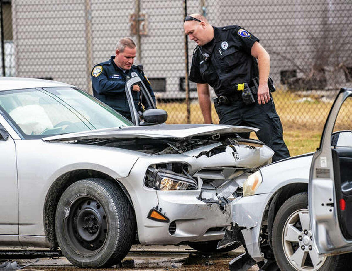 Wood River police officer Chris Alfaro and Alton officer Brian Brenner check out the Dodge Charger that had been reported stolen before fleeing an attempted traffic stop and crashing into another vehicle Thursday afternoon in Wood River.