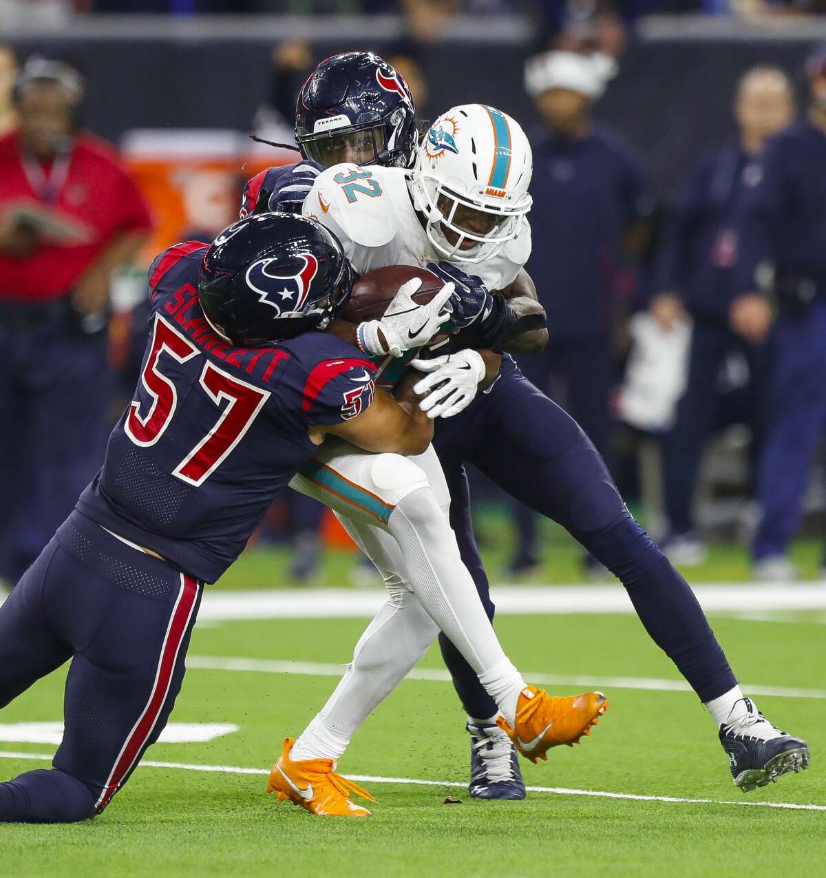 Miami Dolphins running back Kenyan Drake (32) is tackled by Houston Texans linebacker Brennan Scarlett (57) during the fourth quarter of an NFL football game at NRG Stadium on Thursday, Oct. 25, 2018, in Houston.