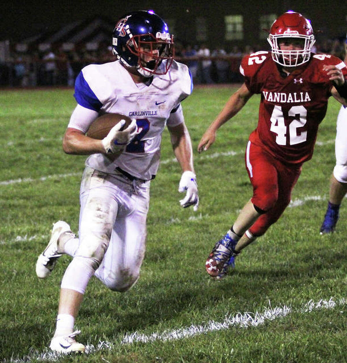 Carlinville’s Colton DeLong (left) heads upfield for a big gain with Vandalia’s Zane Ulmer chasing the play during a Cavaliers’ victory Oct. 5 in Vandalia. The 9-0 Cavaliers are at home Friday night to play EA-WR in a Class 3A playoff game.
