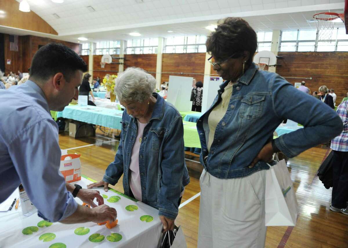 Old Greenwich's Josie Monroe, 96, and her daughter, Eileen Monroe, 71, pariticpate in a vision test from Ryan Venture, of First Light Home Care, at the Health & Wellness Expo at the Eastern Greenwich Civic Center in Old Greenwich, Conn. Thursday, Oct. 11, 2018. Dozens of vendors were on hand to provide information on services for seniors, with this year's theme being "Total Brain Health." There was also a Zumba demonstration, flu shots, mind reader, blood pressure check, relaxation station, vision test and more.