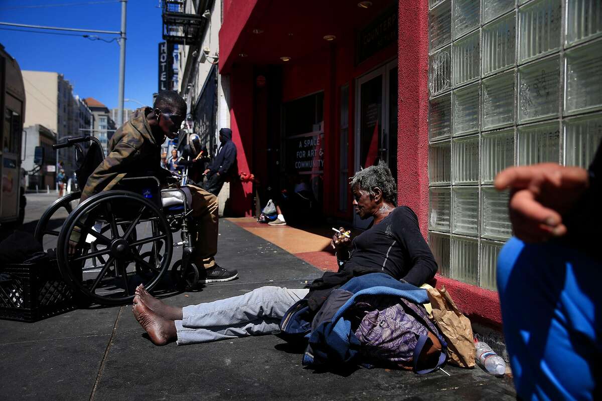 Lauretta Jones (l to r) encourages her friend Deborah Vest to get out of the sun and into the shade as they sit on Turk Street on Wednesday, June 13, 2018 in San Francisco, Calif. Vest says she is currently dealing with homelessness but is on a waiting list to get housing. Jones says she has gotten housing after dealing with homelessness for a couple of months.