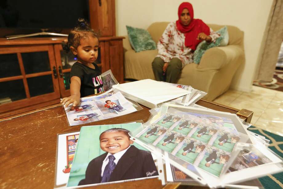 Rahuf Abdalla, 2, looks through a photo album of her brother as her mother, Wigdan Ahmed Mohammed, watches her in their home in Houston. Her brother, Mohammed Ali Abdalla, died 2 years ago after he was hit in a crosswalk. He was 4 years old. Photo: Steve Gonzales/Staff Photographer