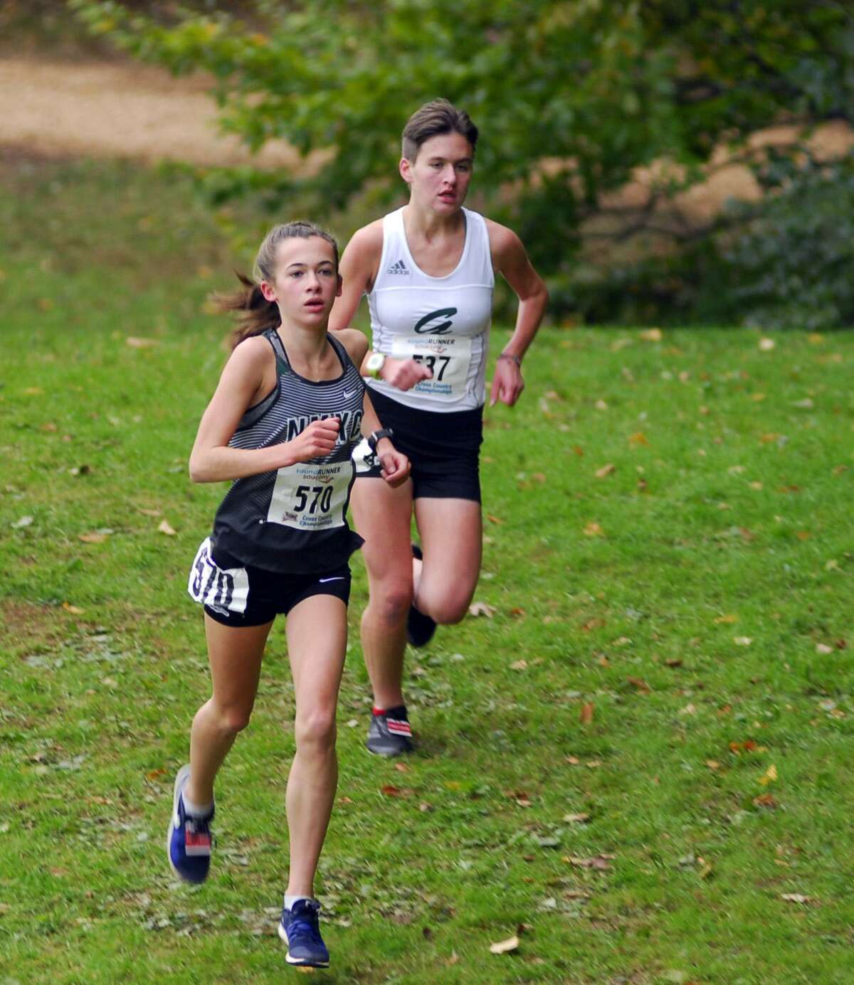 New Milford’s Claire Daniels, left, is ahead of Guilford’s Meredith Bloss during the Class L race on Friday.