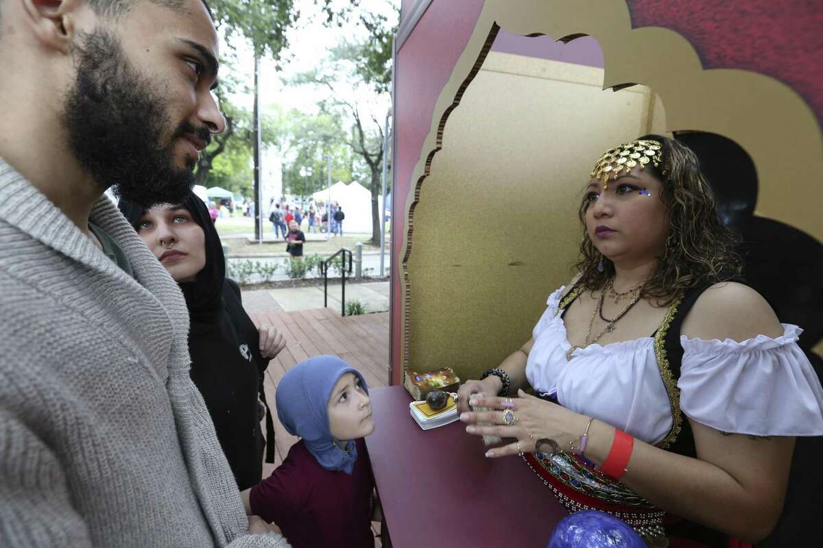 Psychic Victoria Alvarado reads fortune for Ahmed and Hayaam Aldawsari and their daughter, Hayati, 6, at the East End Street Fest on Saturday, Oct. 20, 2018, in Houston.