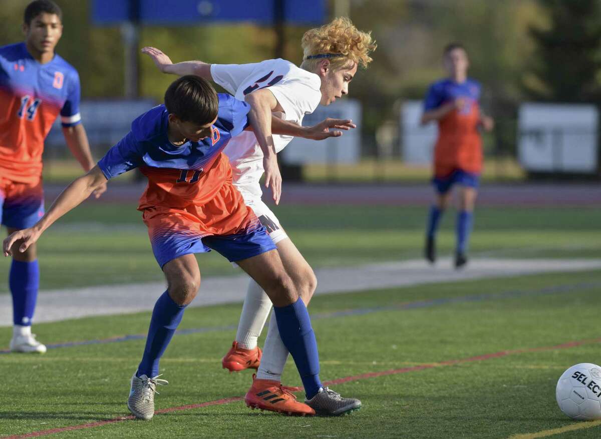 Danbury's Tiago DosReis (11) and McMahon's Lucas Balderrama (22) fight for the ball along the side line in the FCIAC boys Soccer game between Brien McMahon and Danbury high schools, Friday afternoon, October 26, 2018, at Danbury High School, Danbury, Conn.
