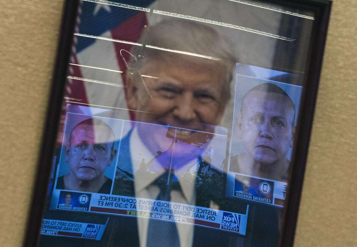 Mugshots of bombing suspect Cesar Sayoc are reflected on a portrait of US President Donald Trump prior to a press conference at the Department of Justice in Washington, DC on October 26, 2018, following the arrest of Sayoc in Florida. - The suspect has been charged with five federal crimes in connection with more than a dozen suspicious packages sent in a US mail bombing spree, Sessions said. (Photo by ANDREW CABALLERO-REYNOLDS / AFP)ANDREW CABALLERO-REYNOLDS/AFP/Getty Images