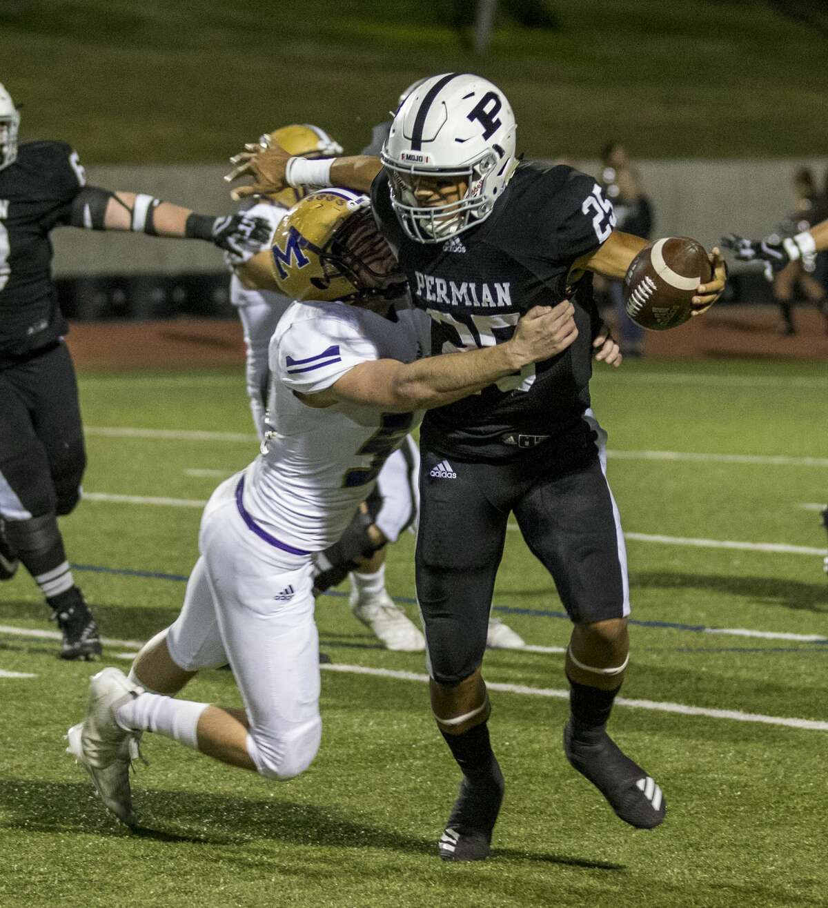 Odessa Permian quarterback Peyton Powell (25) attempts to get away from Midland High's Marshall Mayfield (54) Friday night.