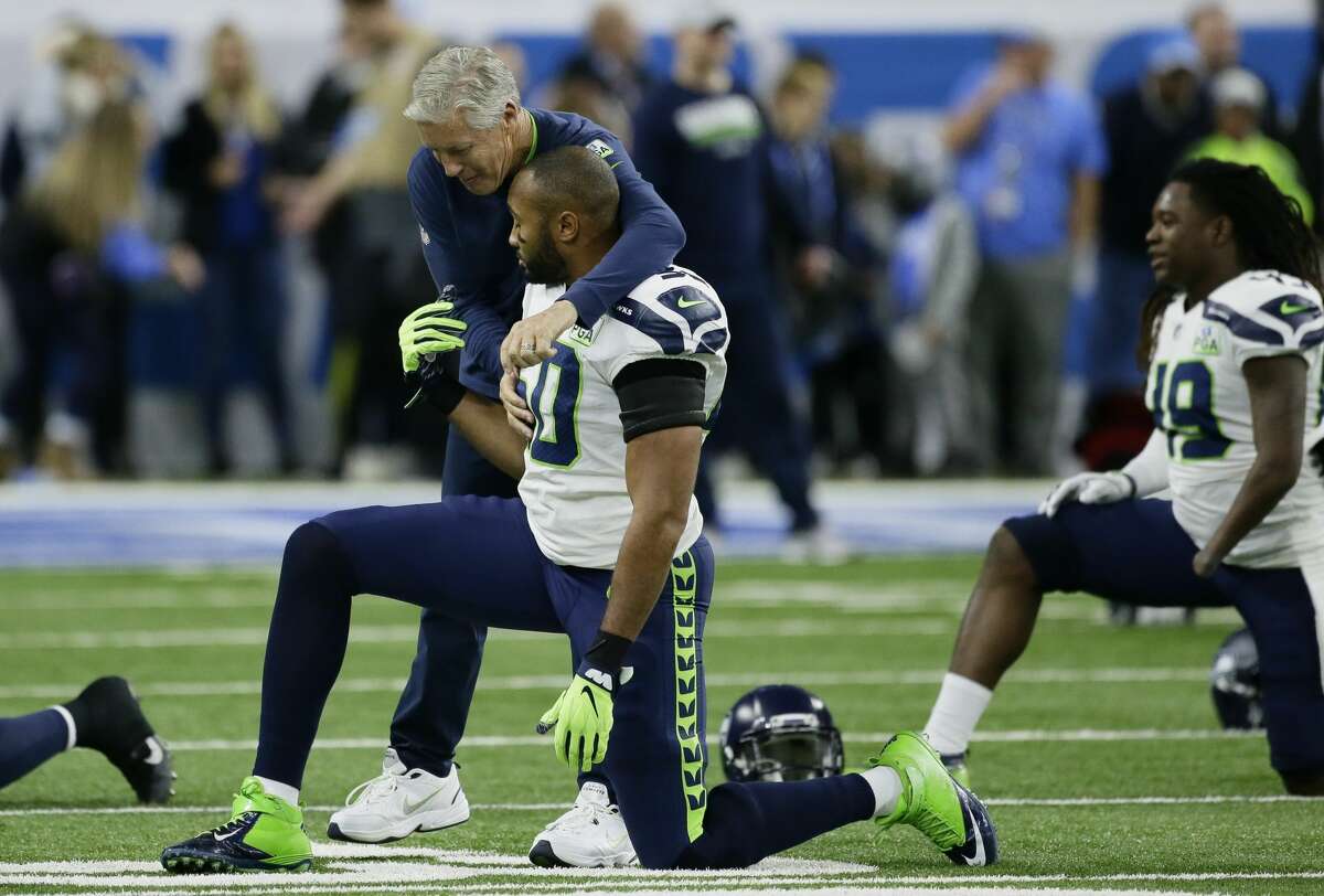 Seattle Seahawks head coach Pete Carroll hugs linebacker K.J. Wright (50) during pregame of an NFL football game against the Detroit Lions, Sunday, Oct. 28, 2018, in Detroit. (AP Photo/Duane Burleson)