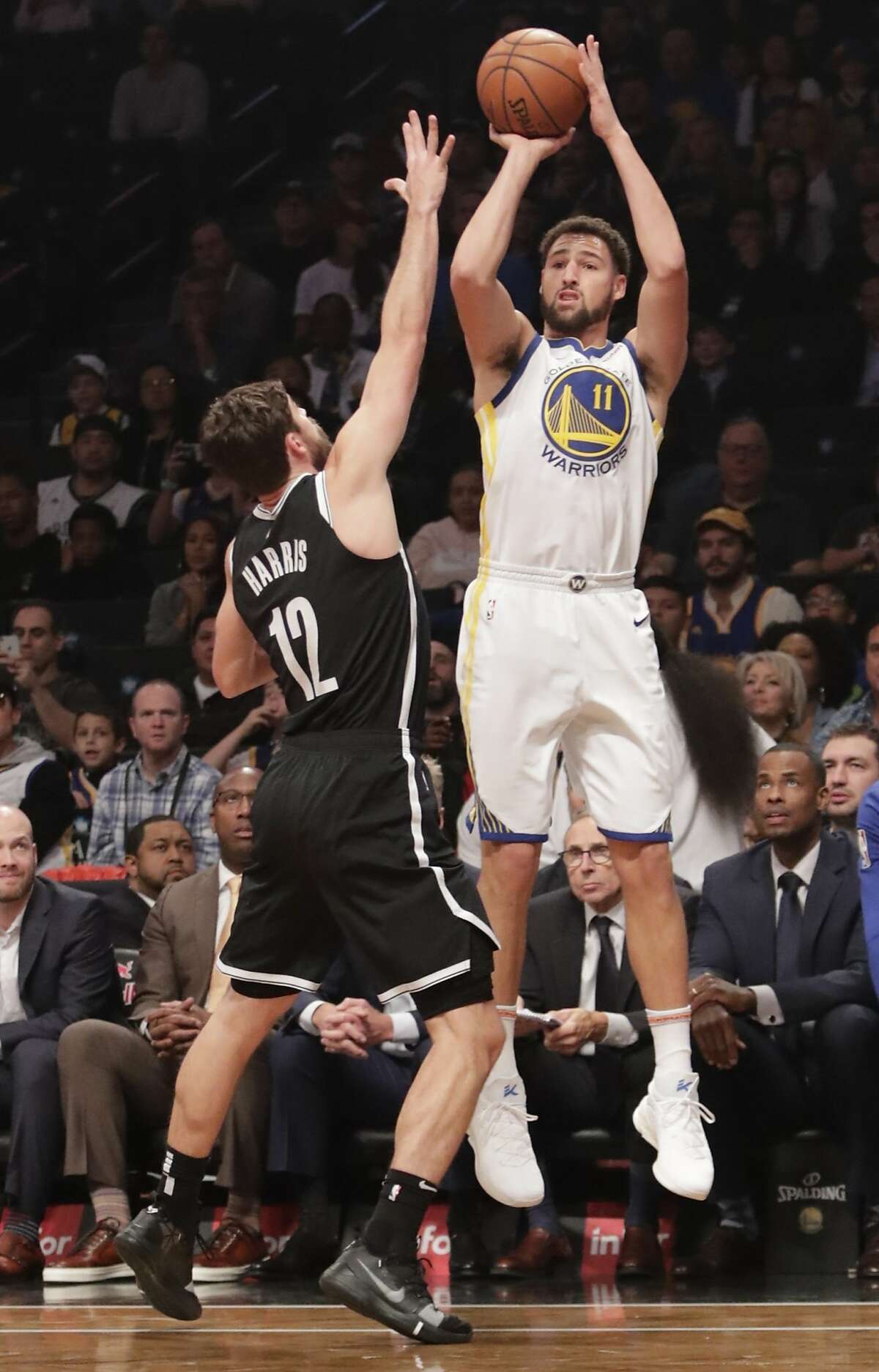Golden State Warriors' Klay Thompson (11) shoots over Brooklyn Nets' Joe Harris (12) during the first half of an NBA basketball game Sunday, Oct. 28, 2018, in New York. (AP Photo/Frank Franklin II)