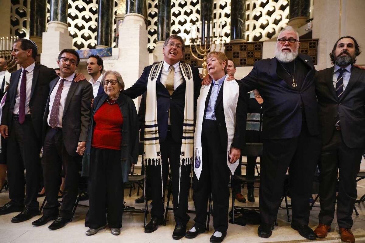 Interfaith leaders sing together at the end of a gathering at Temple Emanu-El in San Francisco marking the synagogue slayings in Pittsburgh.