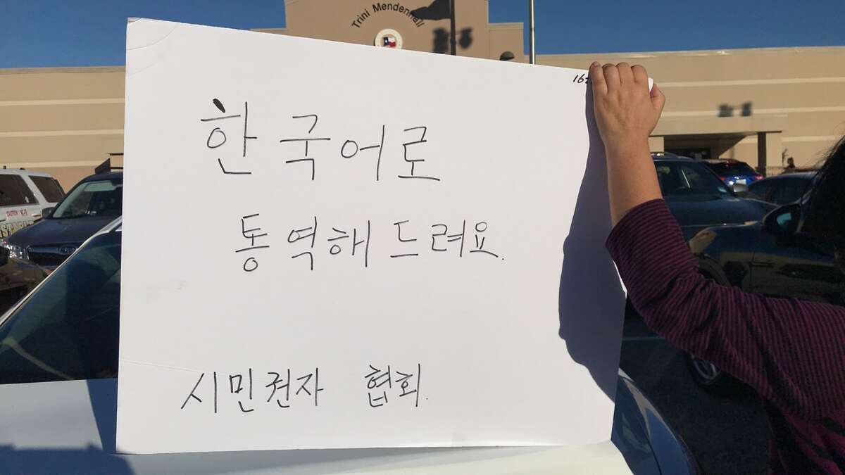 Volunteers on Sunday held a sign that translates "Korean language available".