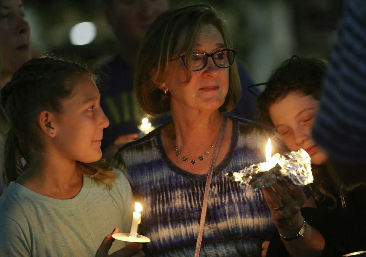 Carly Ostrin, 10, looks at her grandmother, Olivia, with Lila Ostrin, 10, during a vigil on Sunday, October 28, 2018, at the Evelyn Rubenstein Jewish Community Center to honor the victims of the Pittsburgh synagogue attack.