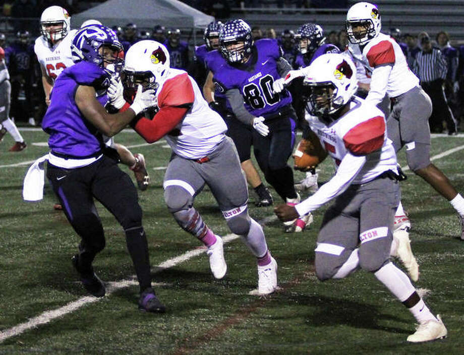 Alton running back Tim Johnson (right) cuts upfield off the block of wide receiver Lonnie Tate (middle) for a 73-yard touchdown run in the second quarter Friday night at Rolling Meadows. The play was called back by a holding penalty on the Redbirds. Photo: Greg Shashack / The Telegraph