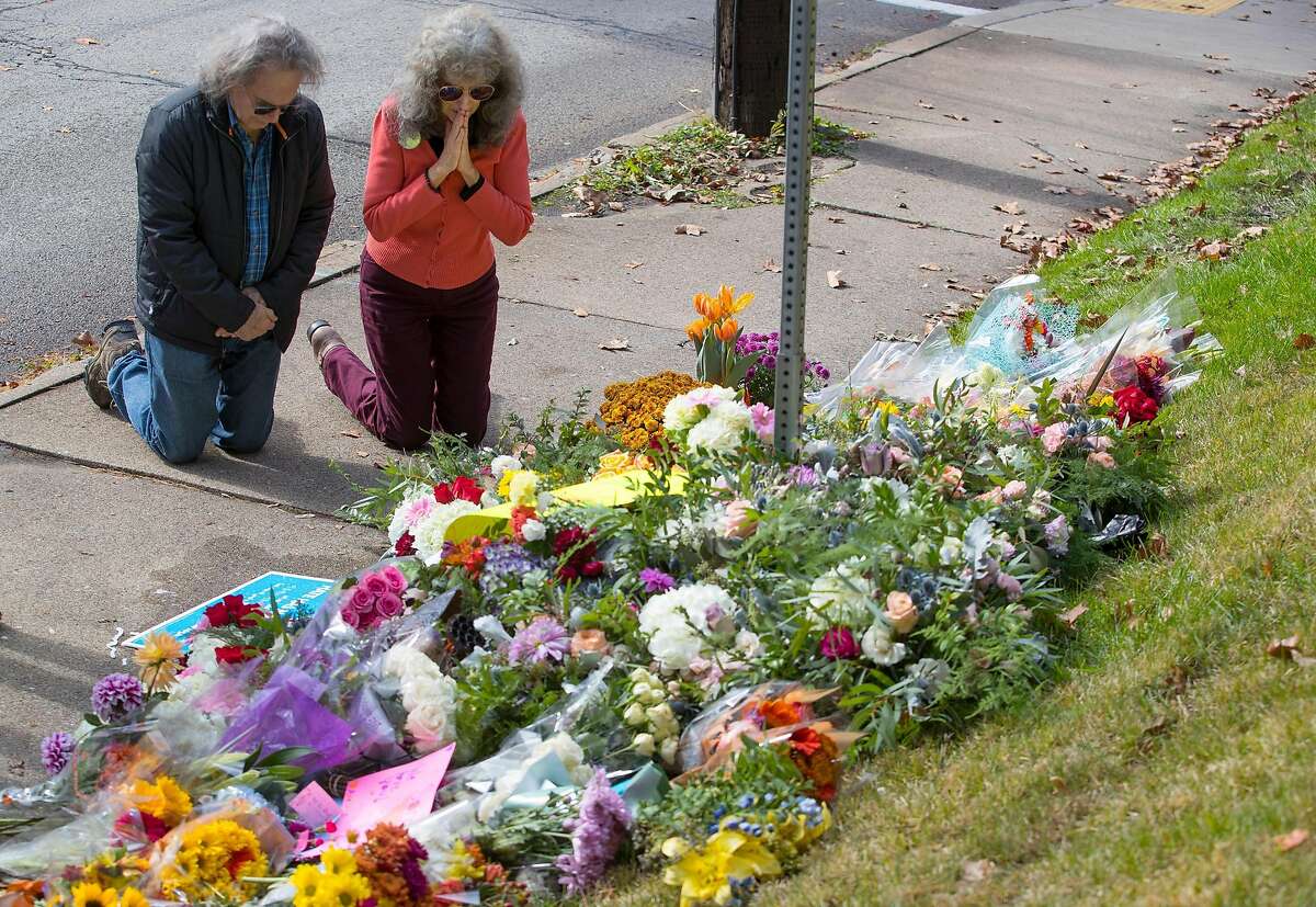 A couple kneels before a memorial at Murray and Wilkins avenues on Sunday, Oct. 28, 2018 in Pittsburgh, Pa. The memorial was for the 11 people that were killed at the shooting at the Tree of Life Synagogue. (Charles Fox/Philadelphia Inquirer/TNS)