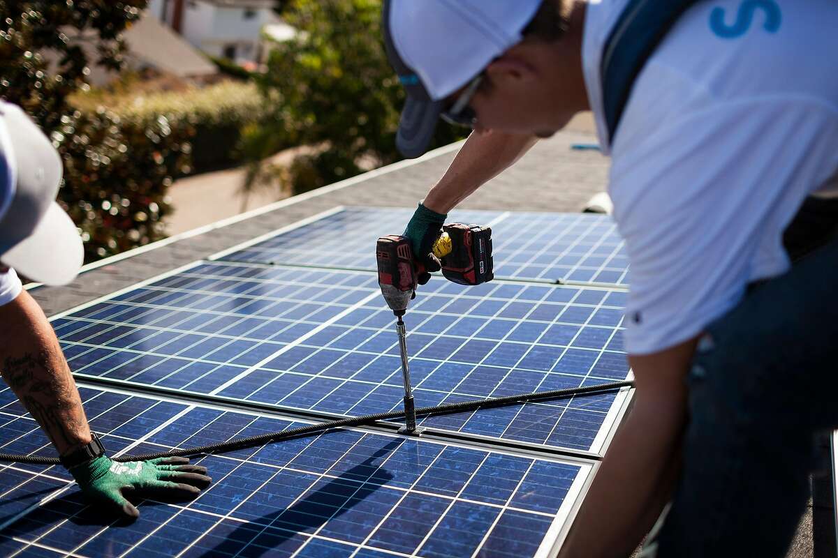 Sunrun installers place a solar panel at a customer’s home in Carlsbad, Calif., Oct. 18, 2018. Tesla is relying on showrooms to sell electric cars, solar roofs and batteries. But a California rival has made inroads into the residential business. (Collin Chappelle/The New York Times)